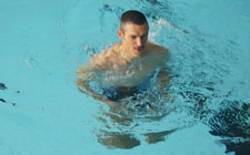 Un uomo corre in una piscina poco profonda (acqua all'altezza del petto).
