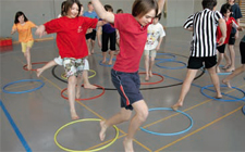 In una palestra dei bambini saltano in alcuni cerchi collocati al suolo a casaccio.