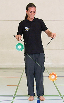 Un homme joue avec deux diabolos simultanément.