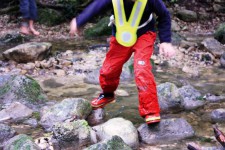 Un bambino mentre guada il torrente