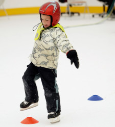 Un bambino esegue uno slalom sul ghiaccio