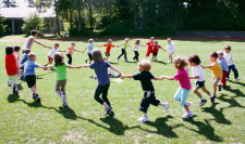 Photo: des enfants se tiennent la main et courent en cercle.