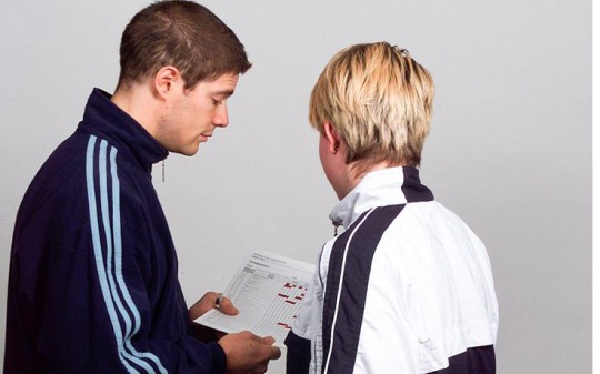 Un allenatore mostra una tabella a una giovane atleta