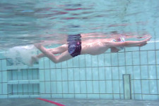 Un bambino parte in freccia ventrale da un bordo della piscina