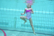 Une fille se maintient à la surface de l'eau en se propulsant avec les jambes.