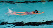 Foto: una bambina nuota a crawl in mezzo alla piscina