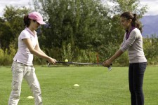 Foto: due ragazze sono una di fronte all'altra e tengono ognuna l'estremità di una mazza da golf
