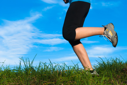 Gros plan sur les jambes d'une femme faisant un jogging dans la nature.