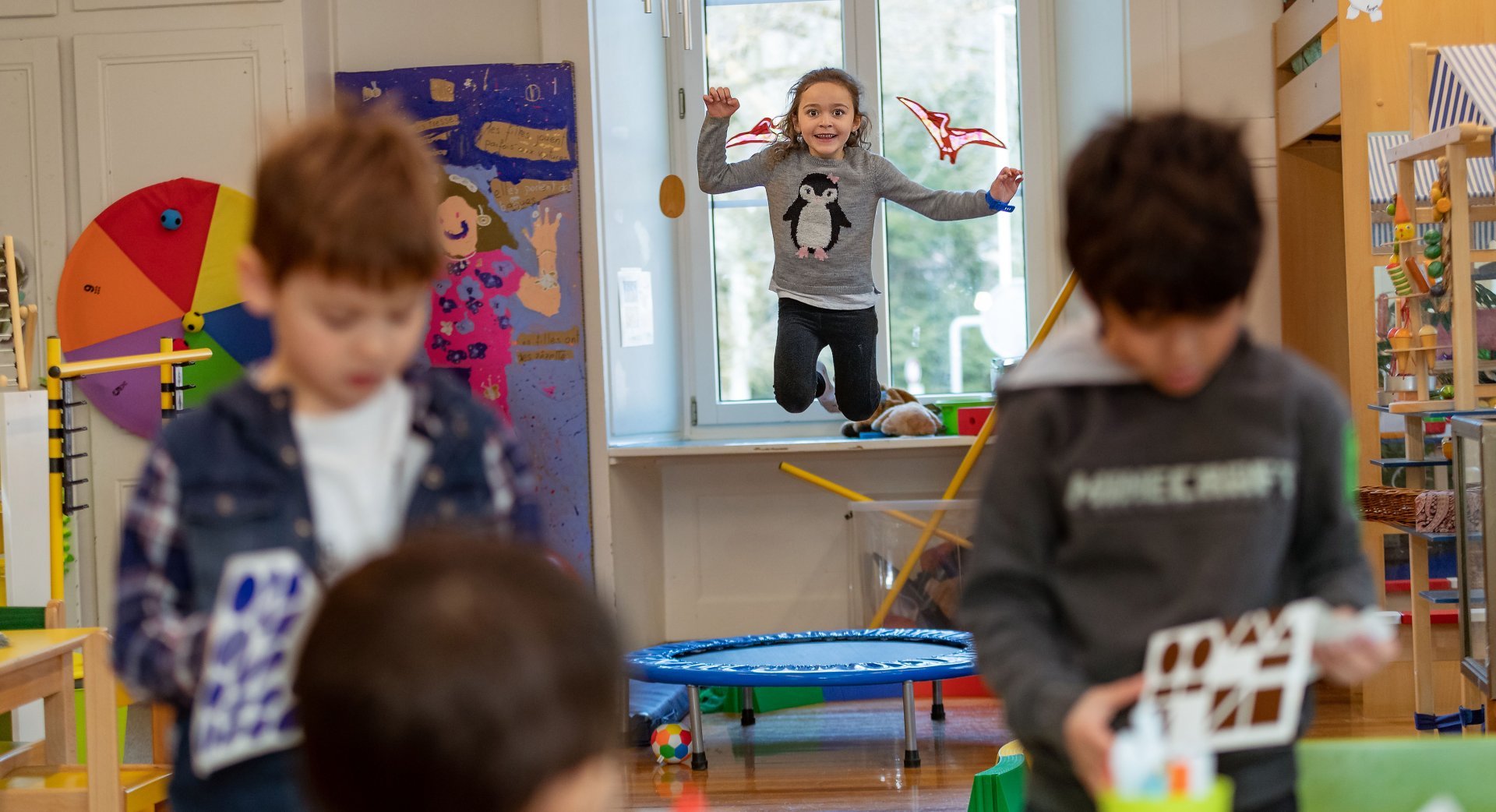 Kinder bewegen sich in einem bewegungsfreundlichen Kindergarten an verschiedenen Geräten und Posten.