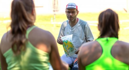 Lehrperson bei Erklärungen an Athletinnen.