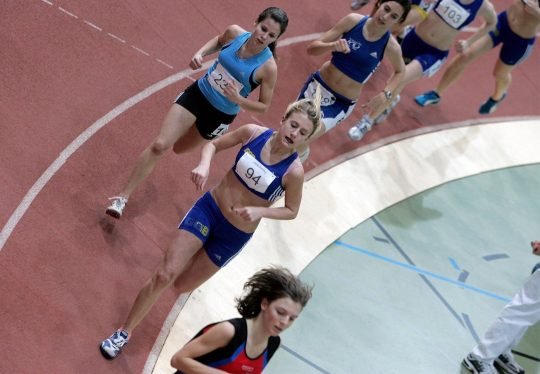 Athleten beim Laufen auf einer Rundbahn.