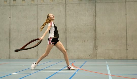 Athletin beim Drehwurf mit einem Veloreifen.