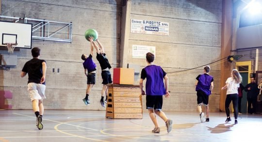 Des jeunes jouent au Poull Ball dans une salle de sport.