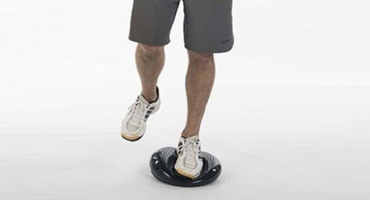 Une personne effectue un exercice sur un support instable sur une jambe.