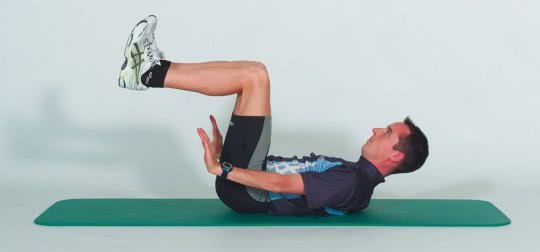Une sportif démontre la position finale d'un exercice de musculature des abdominaux.