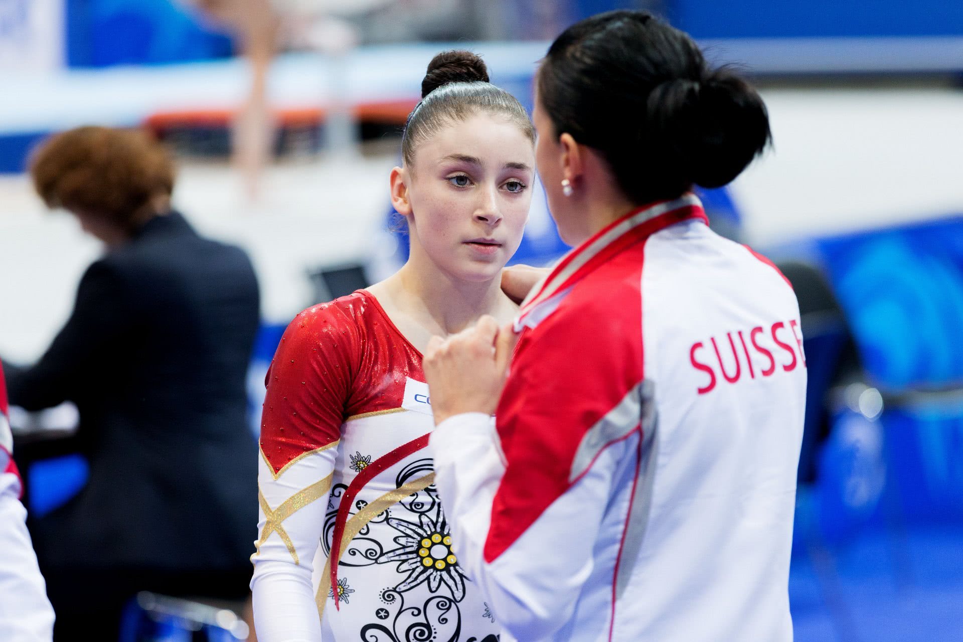 Foto: un'allenatrice parla a una giovane atleta consolandola