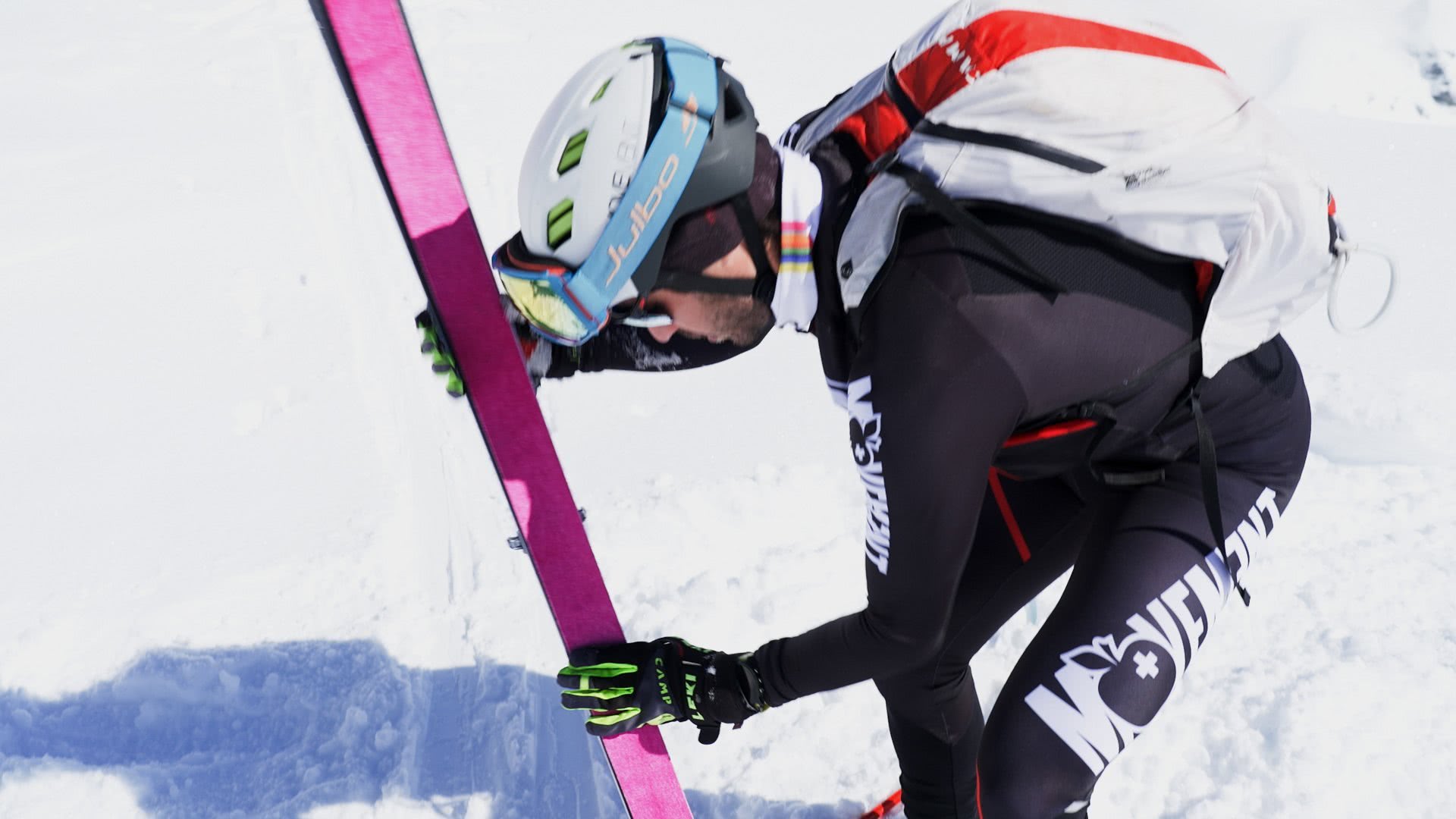 Photo: un skieur colle la peau sur un de ses skis.