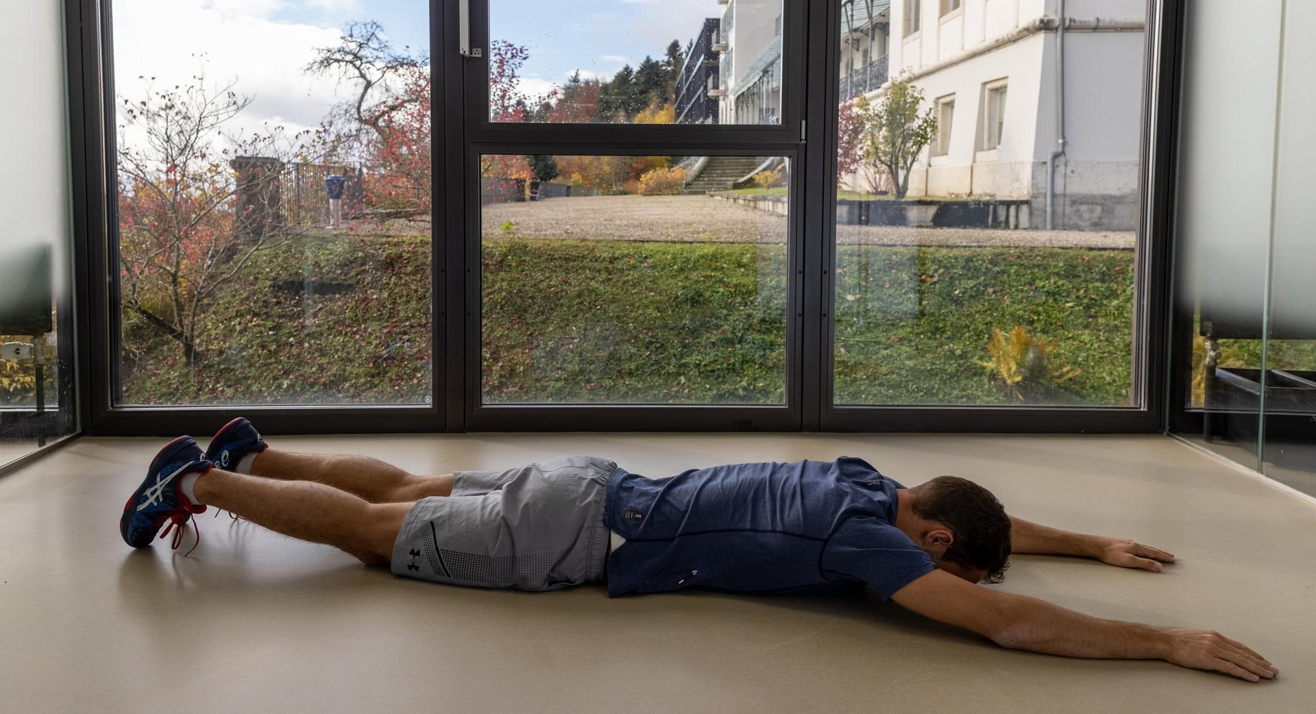 Photo: un homme est couché sur le ventre, les bras tendus dans le prolongement du corps.