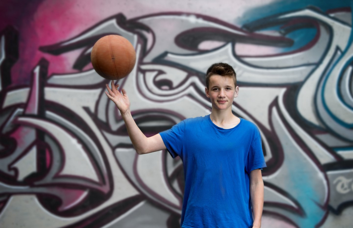 Un ragazzo fa girare un pallone da basket su un dito