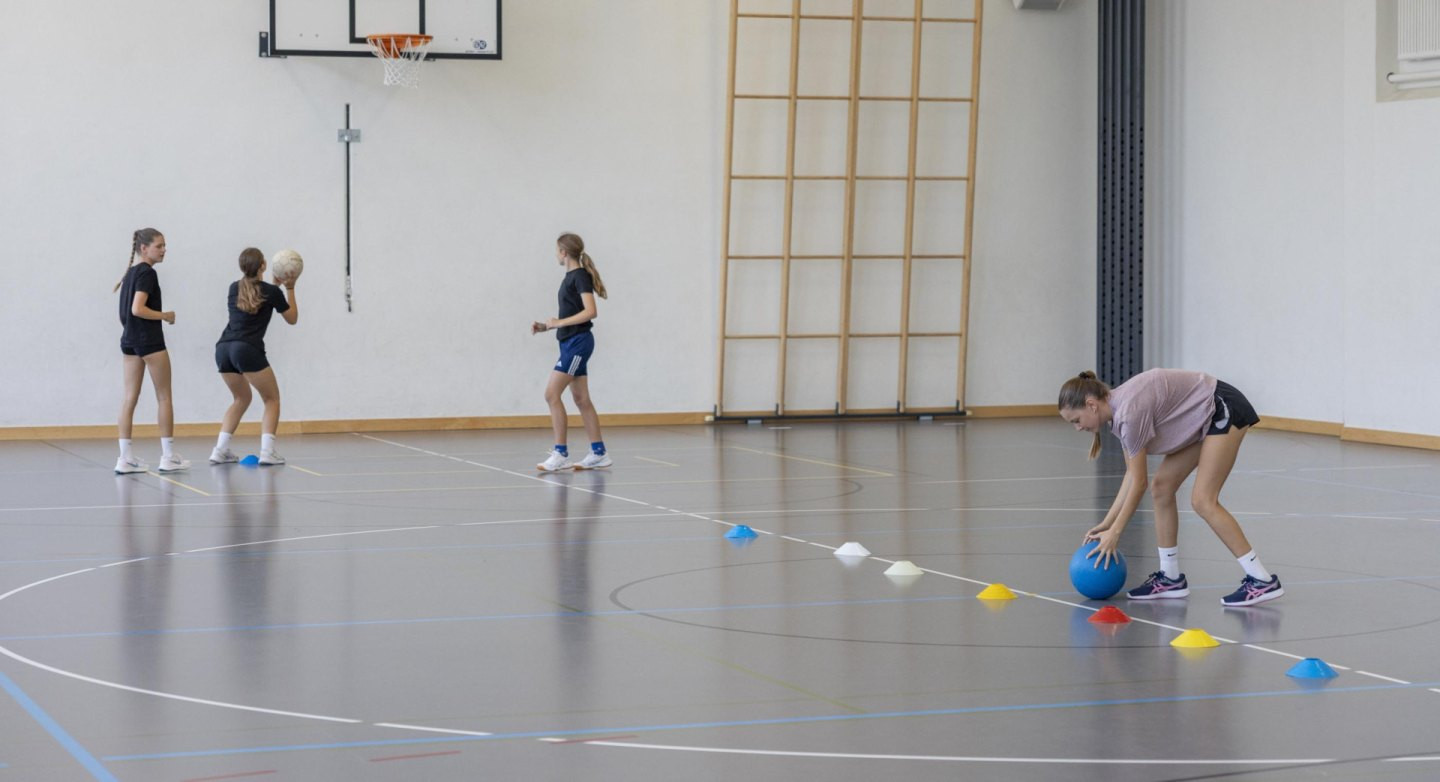 Die Kinder und Jugendlichen erleben eine Drucksituation und werfen darin 
präzise auf den Korb.