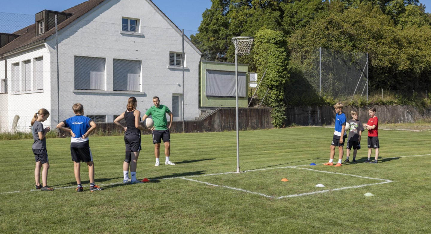 Die Kinder und Jugendlichen werfen aus unterschiedlichen Positionen und unter Druck auf den Korb.