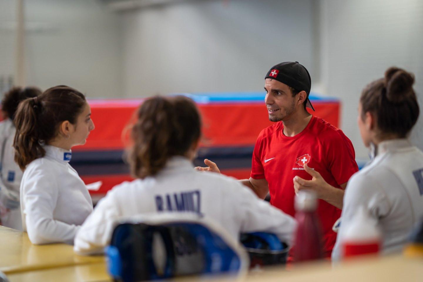 Ein Coach bespricht sich mit drei Athletinnen.