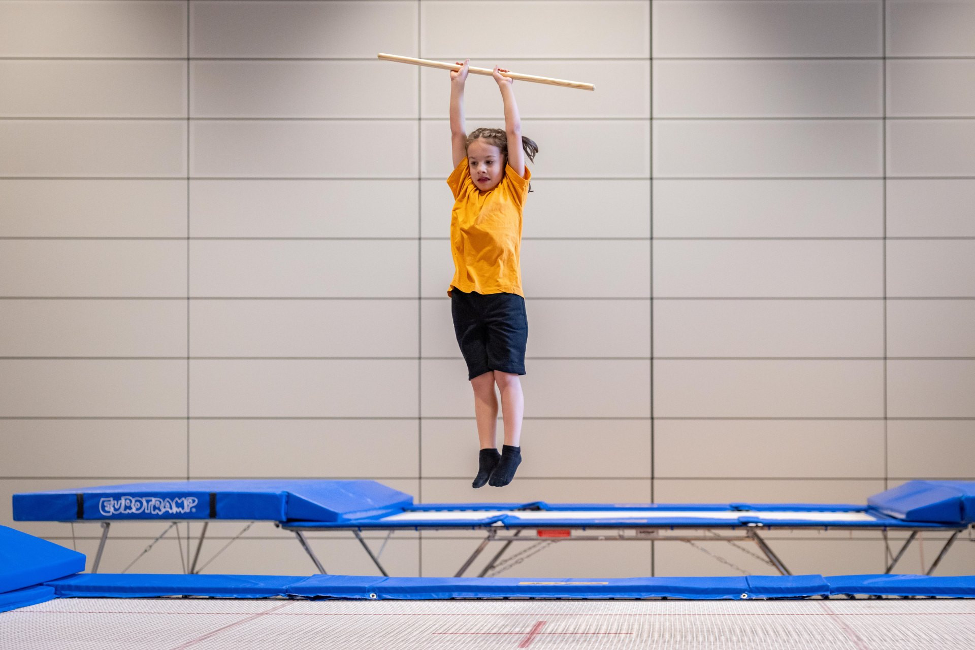 Sul trampolino il ginnasta esegue delle rotazioni sull’asse longitudinale con diversi avvitamenti e si orienta ad alcuni punti fissi sul trampolino. Nel farlo tiene un bastone sopra la testa con le braccia tese.