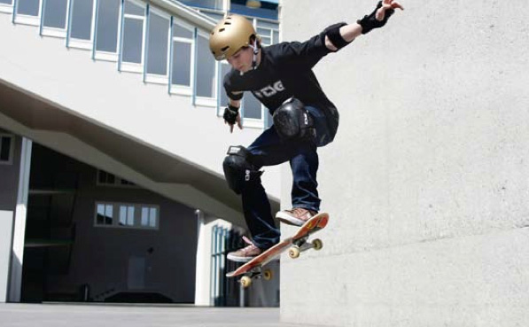 Un jeune effectue une figure en skateboard.