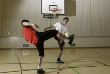 Due giovani si passano una palla con le gambe.