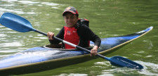 Un bambino su una canoa e indossa un giubbotto di salvataggio rosso