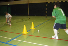 Deux joueurs effectuent des passes entre deux cônes.