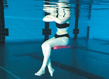 Une femme est assise dans l'eau sur une planche de natation.