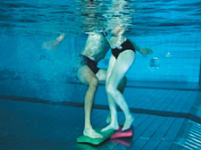 Unterwasseraufnahme: Zwei Personen stehen auf je einem Schwimmbrett. 