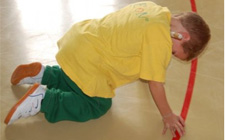 Un bambino in posizione carponi che porta il mento contro il petto.