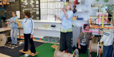 Dei bambini in una classe eseguono vari esercizi su attrezzi diversi