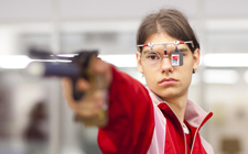 Jugendlicher von vorne beim Zielen, mit Pistole und Schutzbrille.