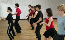 Des hommes et des femmes alignés sur deux rangées dansent le cha-cha-cha.