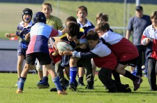 Haufenbildung in einem Rugbyspiel, ein Kind versucht, seinen zahlreichen Gegner zu entwischen.