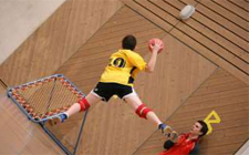 Aufnahme von oben: ein Kind wirf den Ball auf einen Tchoukball-Rahmen.