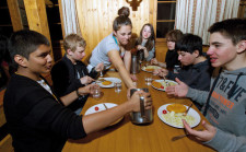 Des garçons et filles partagent un repas à une table.