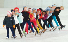 Diversi bambini disposti in fila uno dietro l'altro in posa sul ghiaccio.