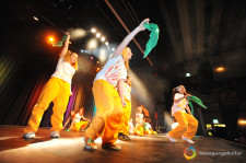 Des jeunes filles dansent avec un foulard dans la main sur une tribune
