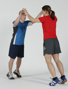 Due atleti sono uno di fronte all'altro sulle punte dei piedi. Le mani sono unite sopra le loro teste.