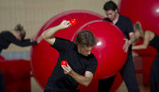 De jeunes gens jouent avec des balles rouges de différentes tailles.