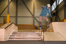 Uno skateboarder esegue un frontside lipslide su un downrail.