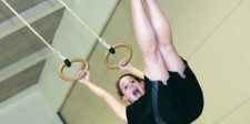 Une jeune fille se balance aux anneaux.
