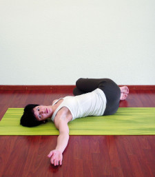 Une femme est allongée sur le dos jambes fléchies (paquet), les jambes descendent sur le côté