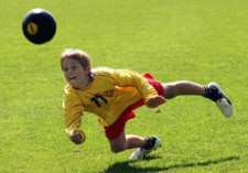 Un enfant plonge pour frapper un ballo.
