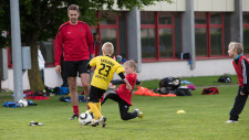 Un allenatore osserva un bambino mentre conduce la palla da un punto A a un punto B