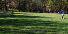 Un ragazzo lancia un frisbee in un parco